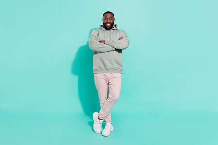 Full length body size view of attractive content cheery guy folded arms isolated over bright teal...