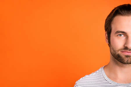 Cropped photo of young man calm focused stubbled hair care empty isolated over orange color...