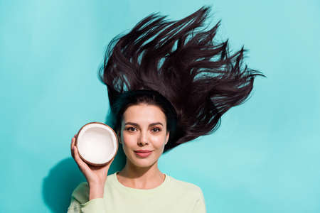 High angle top view photo of lady hold tropical cocos new shampoo lotion flavor silky hairstyle isolated on cyan color backgroundの写真素材