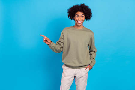 Photo of youth excited guy indicate finger empty space decision banner direct way suggest isolated over blue color backgroundの写真素材