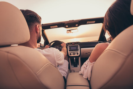 Photo of sweet pretty husband wife wear white outfits smiling riding automobile enjoying sunset outside country side routeの写真素材