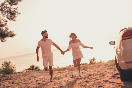 Photo of carefree charming husband wife wear white outfits smiling riding automobile running beach outside country side routeの写真素材