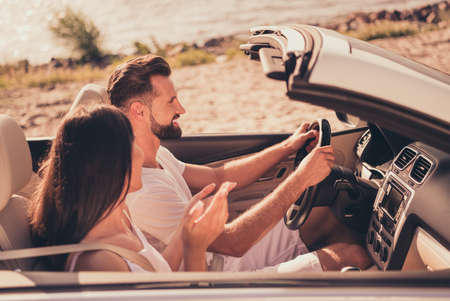 Photo of pretty sweet married couple dressed white clothes driving car talking smiling outdoors...