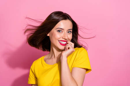 Photo of sweet charming young woman wear yellow outfit air blowing biting finger smiling isolated pink color backgroundの写真素材