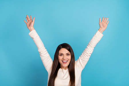 Photo of young cheerful girl good mood hands up rejoice lucky discount isolated over blue color...