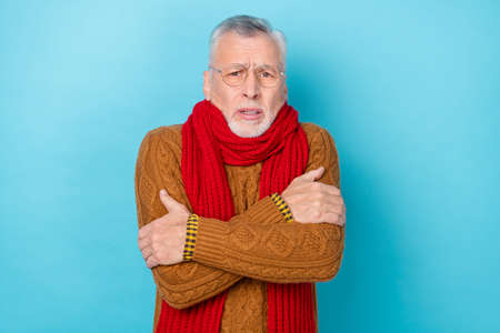 Photo of upset man touch hands infection shoulders bad feel frosty isolated blue color backgroundの写真素材