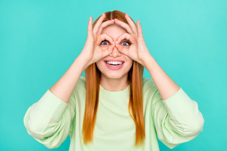 Photo of pretty childish young woman wear green outfit showing arms spectacles smiling isolated...