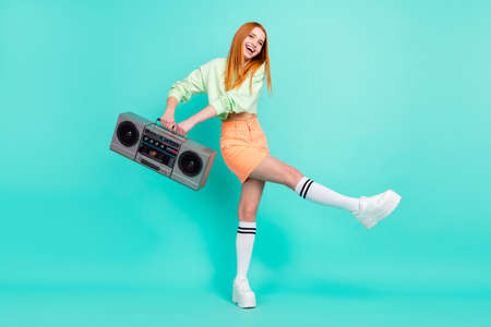 Full length body size photo pretty red haired girl dancing keeping retro tape recorder isolated...
