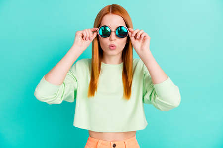 Photo of shiny impressed young woman wear green shirt arms dark glasses lips pouted isolated teal...