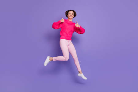 Full body photo of cheerful girl have fun show two thumbs up wear trousers shoes isolated on violet color backgroundの写真素材