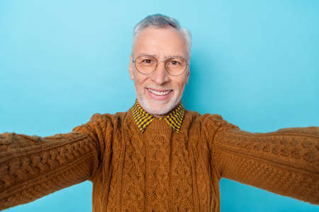 Photo of positive middle aged man make selfie video call trip isolated sky light color backgroundの写真素材