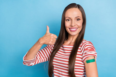 Photo of young lovely lady show thumb-up perfect choose vaccination health care isolated over blue...