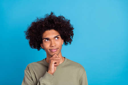 Photo of young handsome guy hand touch chin look empty space think clever minded isolated over blue...