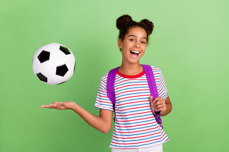 Photo of young black girl happy positive smile play football game sport school isolated over green color backgroundの写真素材