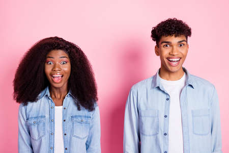Portrait of astonished dark skin guy lady open mouth unbelievable news isolated on pink color backgroundの写真素材