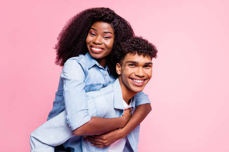 Photo of handsome dark skin guy piggyback attractive lady toothy smile isolated on pink color backgroundの写真素材