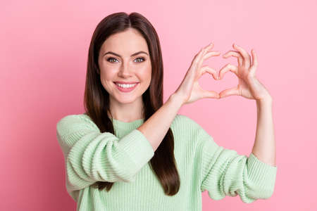 Portrait of satisfied person show arms fingers heart figure toothy smile isolated on pastel pink...