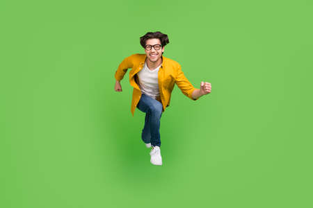 Full size photo of young handsome positive guy in glasses running fast in air traveling isolated on...