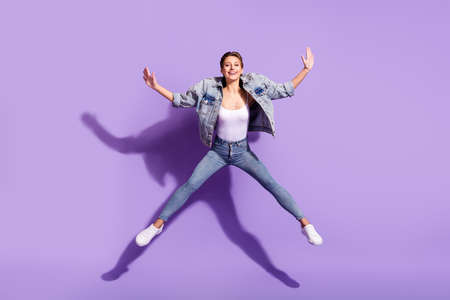 Full body photo of young cheerful active woman jump up raise hands isolated on purple violet color...