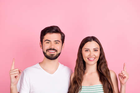 Photo of promoter couple indicate forefingers up empty space wear casual outfit isolated pink color backgroundの写真素材