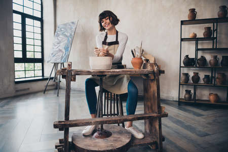 Full length photo of artistic lady pottery owner have pot forming seminar show artwork doing in workroomの写真素材
