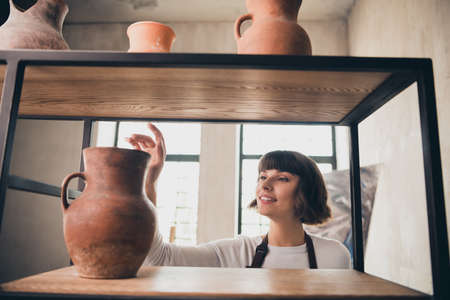 Photo of skilled lady pottery artwork small business owner enjoy new modeling clay product in workroomの写真素材