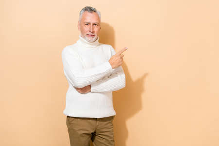 Portrait of attractive content grey-haired man demonstrating copy empty blank space ad isolated over...