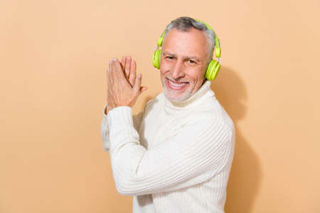 Portrait of attractive cheerful grey-haired man listening pop having fun dancing pastime isolated...