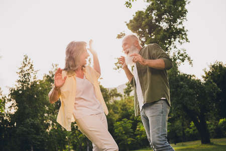 Profiile photo of funny aged white hair couple dance wear casual shirts outside weekend in parkの写真素材