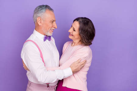 Profile portrait of two lovely soulmates hug dance affectionate isolated on purple color backgroundの写真素材