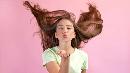 Photo of dreamy romantic lady haircut flying send air kiss flirt boyfriend isolated over pastel color backgroundの写真素材