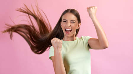Photo of delighted lady hear news new shampoo anti dander effect come raise fists up win isolated...