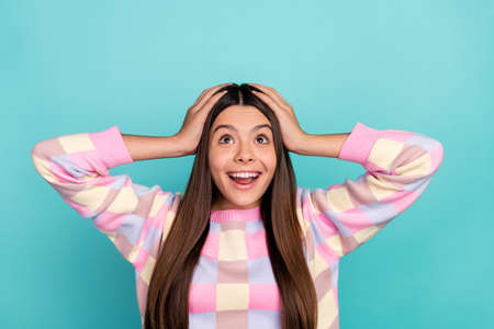 Photo of young cheerful girl amazed look empty space unexpected isolated over turquoise color...