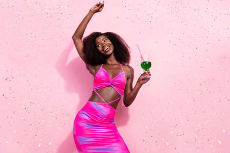 Portrait of attractive carefree cheerful wavy-haired girl drinking cocktail dancing isolated over...