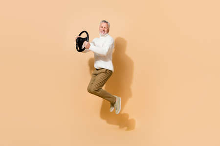 Full length body size view of attractive cheery man jumping holding steering wheel study isolated...