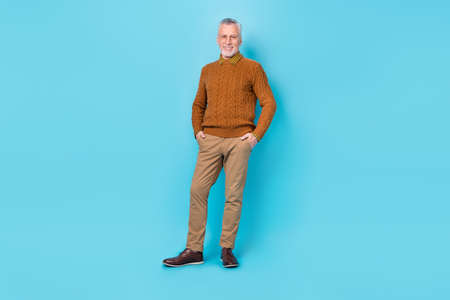 Photo of positive cheerful man put hands pockets isolated over sky light color background.