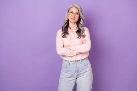 Portrait of attractive intelligent cheerful woman specialist folded arms isolated over violet purple color backgroundの写真素材