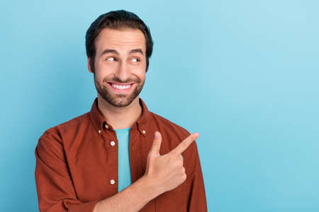 Portrait of funky positive guy look copyspace promoting product recommendation isolated on blue...