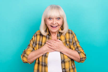 Photo of mature woman arms on chest excited reaction information isolated over turquoise color...