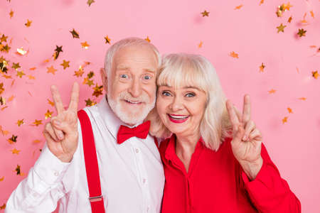 Photo of trendy pensioner retired elegant lady man make v-sign air fly confetti isolated pastel color backgroundの写真素材