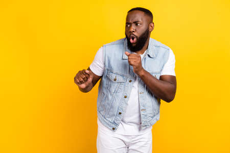 Portrait of attractive funny cheerful guy dancing good mood having fun isolated over bright yellow color backgroundの写真素材