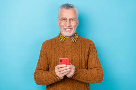 Photo of middle aged man blogger use smart gadget texting follow comment isolated blue color backgroundの写真素材