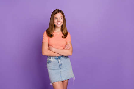 Portrait of attractive cheerful teen girl folded arms thinking copy blank space isolated over vibrant violet purple color backgroundの写真素材