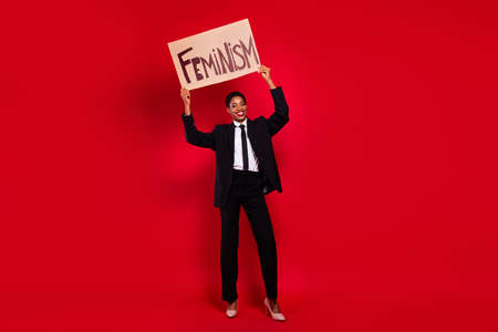 Full length photo of young man woman hold billboard protest women rights isolated over red color backgroundの写真素材