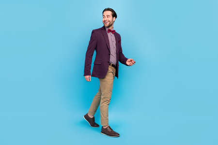 Full length profile side photo of young excited guy wonder look empty space walk isolated over blue color backgroundの写真素材