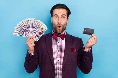 Photo of attractive luxury dress code formalwear man hold fan on money salary isolated on blue color backgroundの写真素材