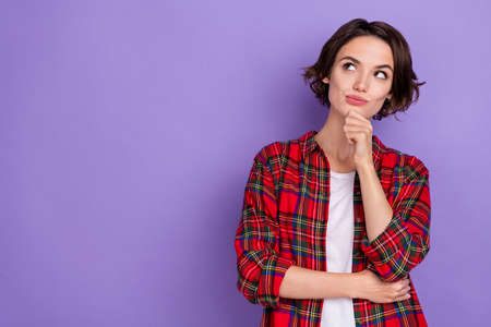 Photo of thinking young bob hairdo lady look promo wear red shirt isolated on purple color backgroundの写真素材