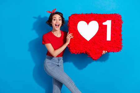 Photo of young cheerful girl glad popular app user repost feedback isolated over blue color backgroundの写真素材