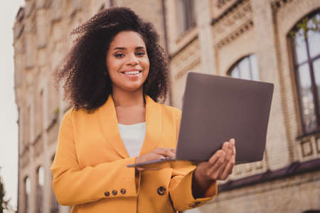 Portrait of attractive skilled experienced cheerful girl freelancer traveling using holding laptop...