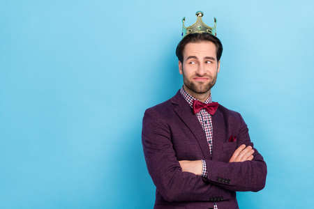 Photo of young man royal folded hands look empty space thoughtful wonder isolated over blue color backgroundの写真素材